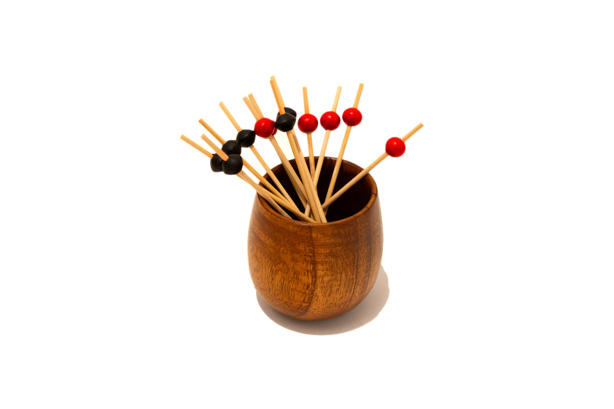 Red and black ball picks in a wooden cup